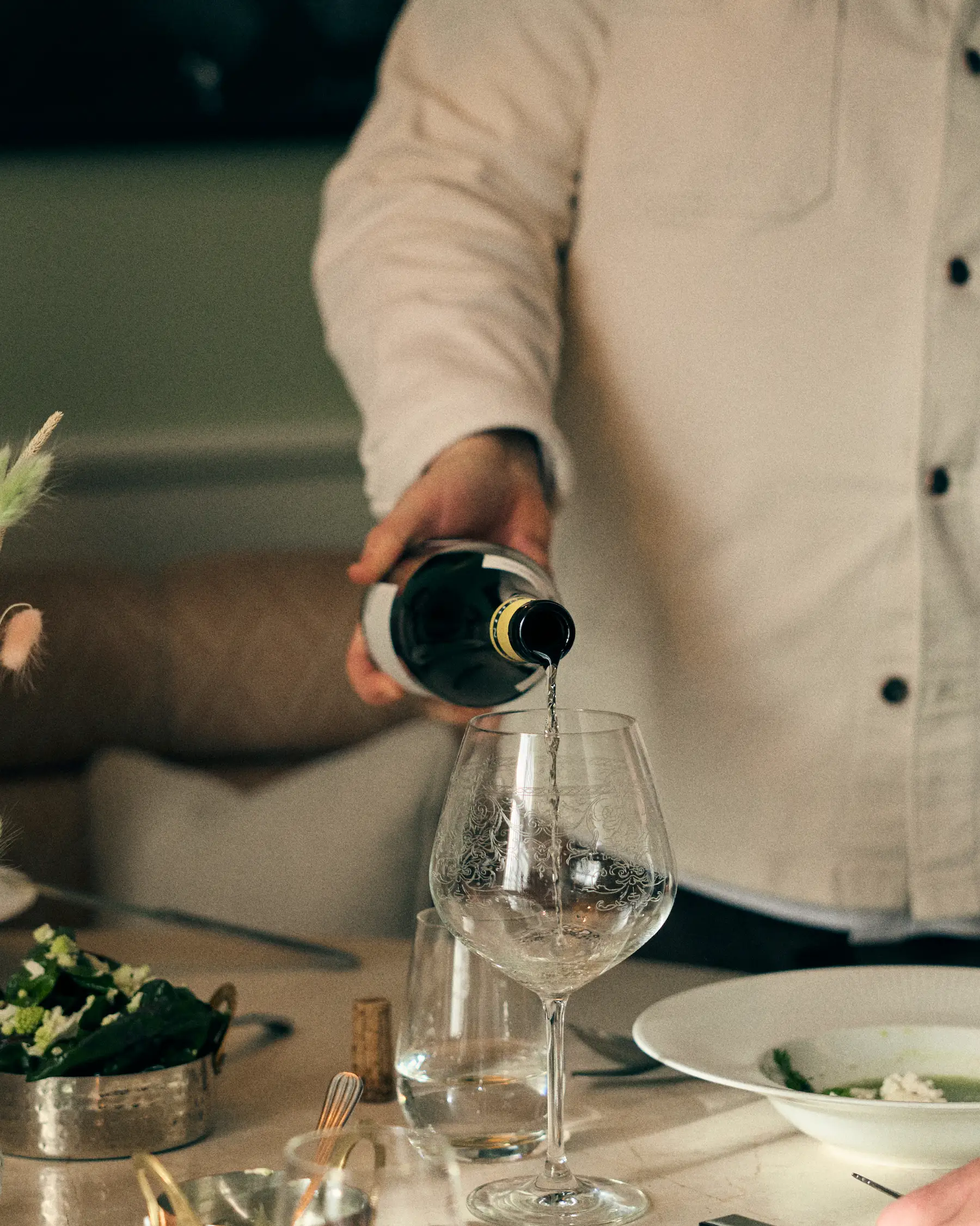 Maryhill_Estate_Vindestination_5 Vin hälls upp i ett vinglas vid ett dukat bord